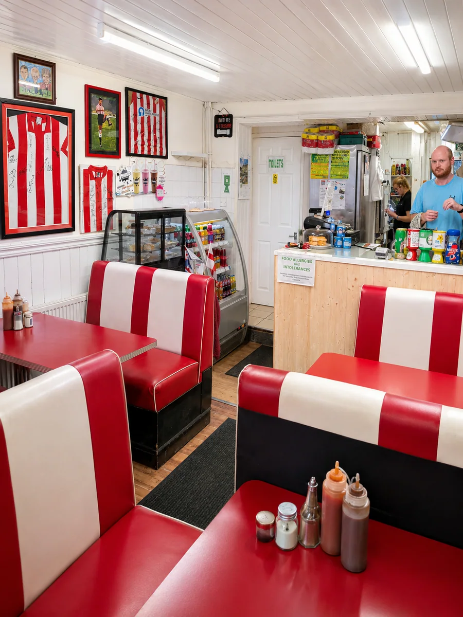 Red and white booths and the counter inside The Corner Cafe