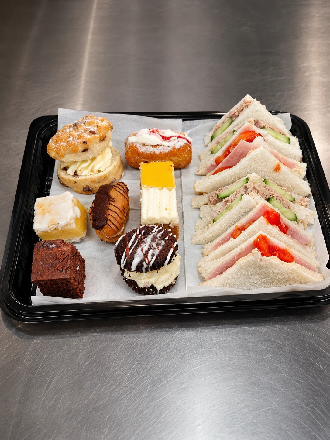 Sandwiches and sweet bakes arranged on a cafe platter